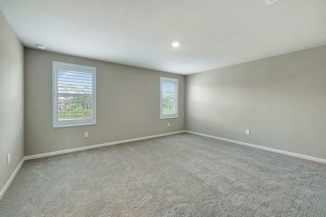 carpeted spare room featuring a textured ceiling