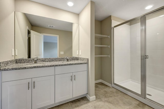 bathroom featuring vanity, tile patterned flooring, and walk in shower