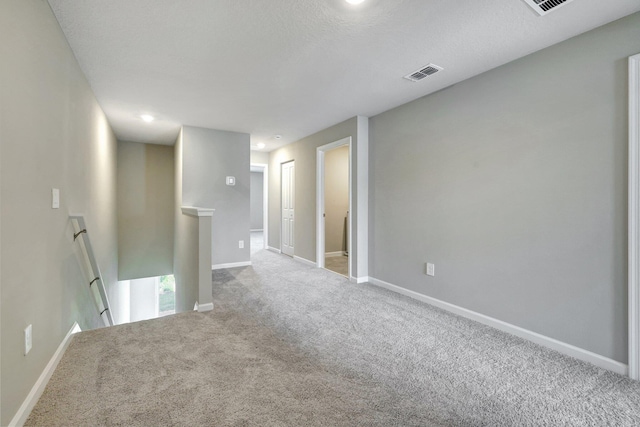 spare room with carpet floors and a textured ceiling