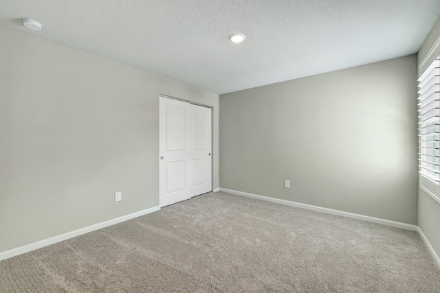 carpeted spare room featuring a textured ceiling