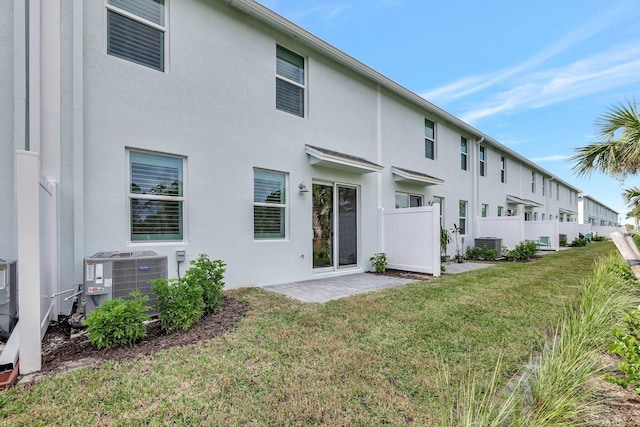 back of property with central AC, a yard, and a patio area