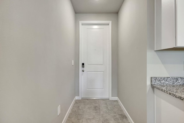 doorway to outside with light tile patterned flooring