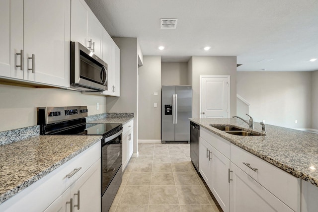 kitchen featuring sink, light tile patterned floors, white cabinetry, stainless steel appliances, and light stone countertops