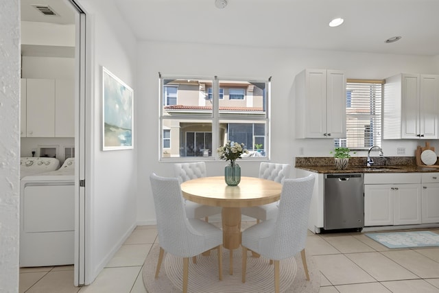 dining space with washing machine and clothes dryer, sink, and light tile patterned flooring