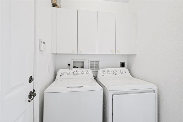 laundry area with cabinets and separate washer and dryer