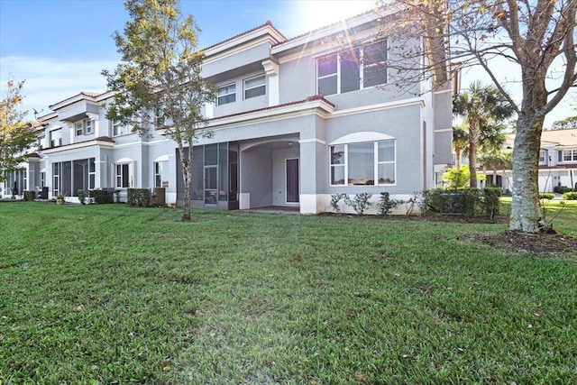 townhome / multi-family property featuring a sunroom and a front yard