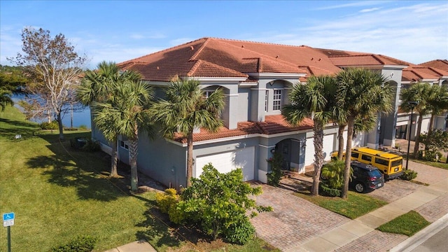 mediterranean / spanish house with a garage and a front yard