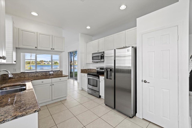 kitchen with sink, white cabinets, stainless steel appliances, and light tile patterned floors