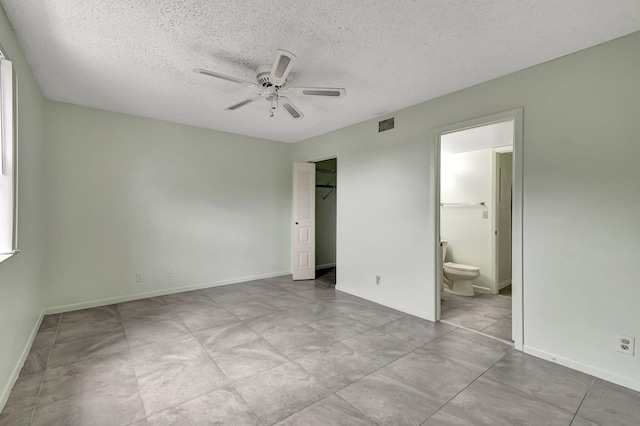 unfurnished bedroom with a textured ceiling, a closet, ensuite bath, and ceiling fan