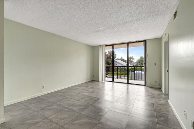 unfurnished room with expansive windows and a textured ceiling