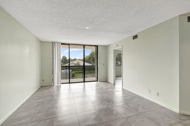 spare room featuring a textured ceiling and expansive windows