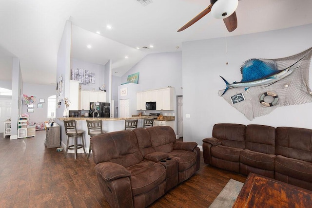 living room with ceiling fan, high vaulted ceiling, and dark wood-type flooring