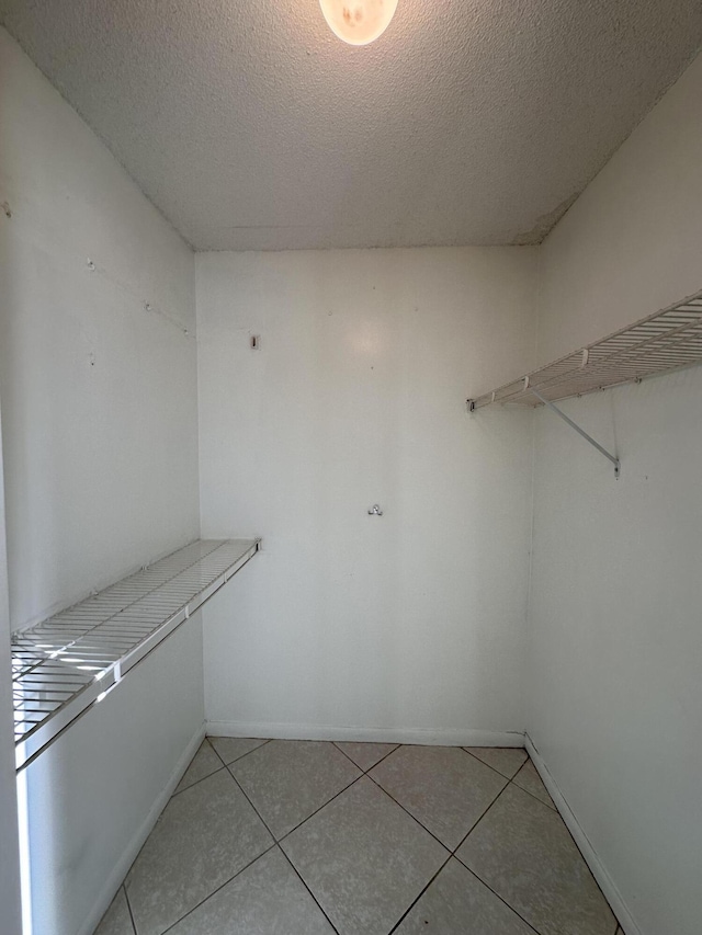 walk in closet with light tile patterned floors