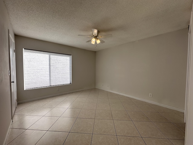 tiled spare room featuring a textured ceiling and ceiling fan