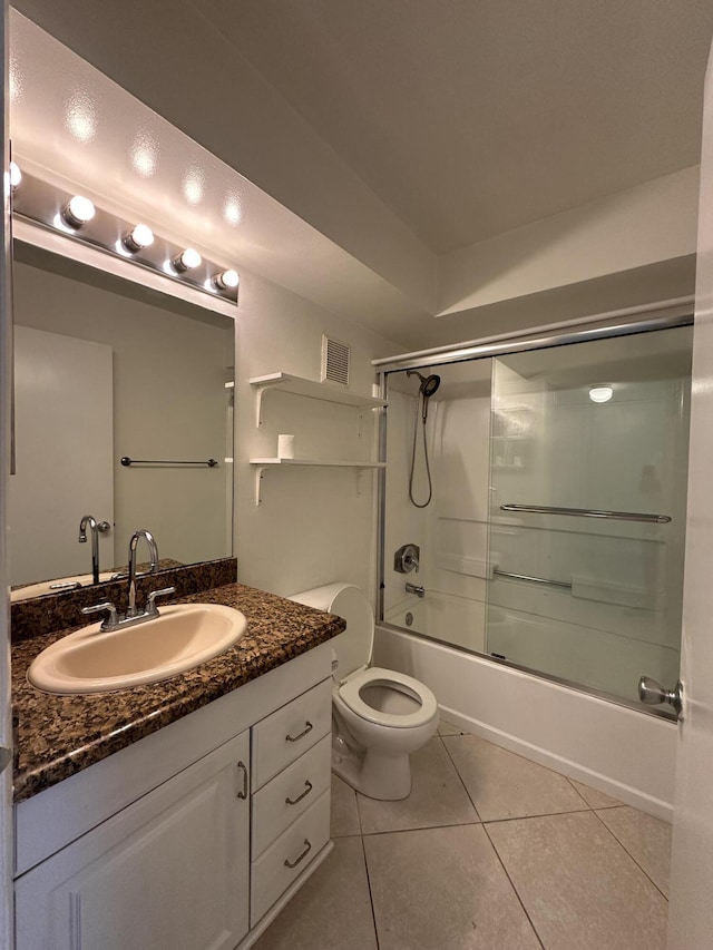 full bathroom featuring enclosed tub / shower combo, vanity, toilet, and tile patterned flooring