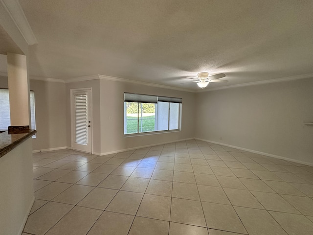 spare room featuring ornamental molding, a textured ceiling, and light tile patterned floors