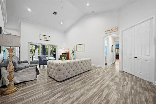 living room featuring ornamental molding, high vaulted ceiling, and light hardwood / wood-style floors