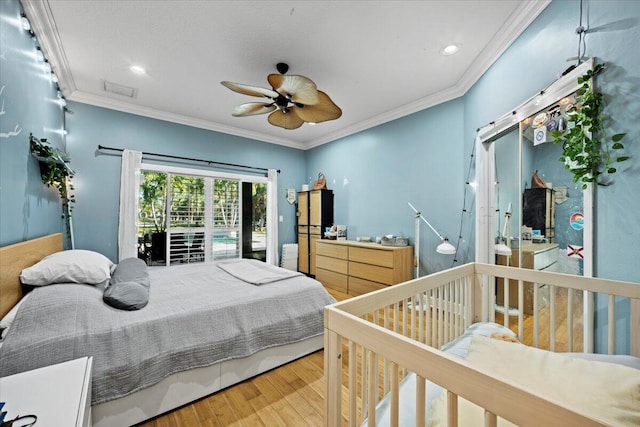 bedroom featuring hardwood / wood-style floors, ornamental molding, and ceiling fan