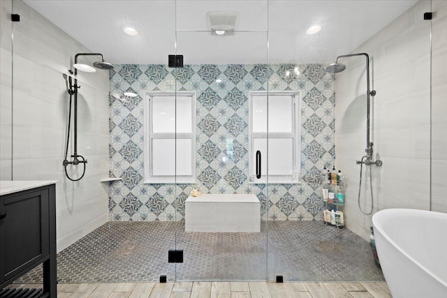 bathroom featuring vanity, hardwood / wood-style floors, and plus walk in shower