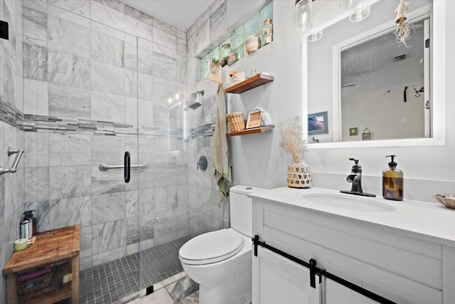 bathroom with vanity, a shower with shower door, and toilet