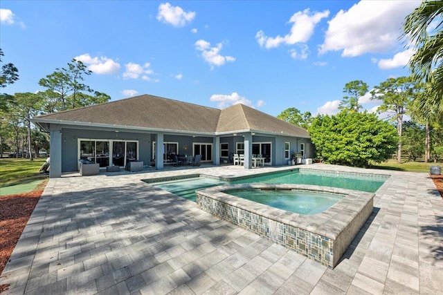 view of pool featuring a patio and an in ground hot tub