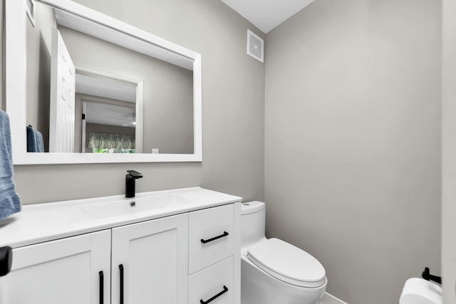 bathroom with visible vents, toilet, ceiling fan, and vanity