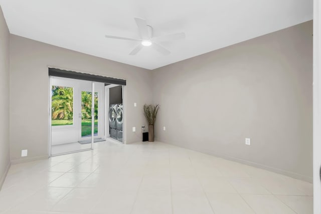 empty room featuring light tile patterned floors, separate washer and dryer, baseboards, and ceiling fan