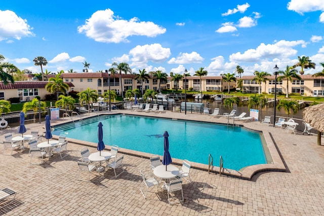 view of pool with a water view and a patio