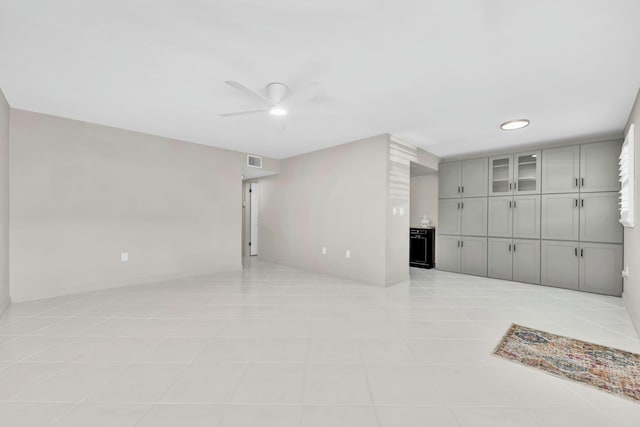 unfurnished living room with light tile patterned floors, visible vents, and ceiling fan