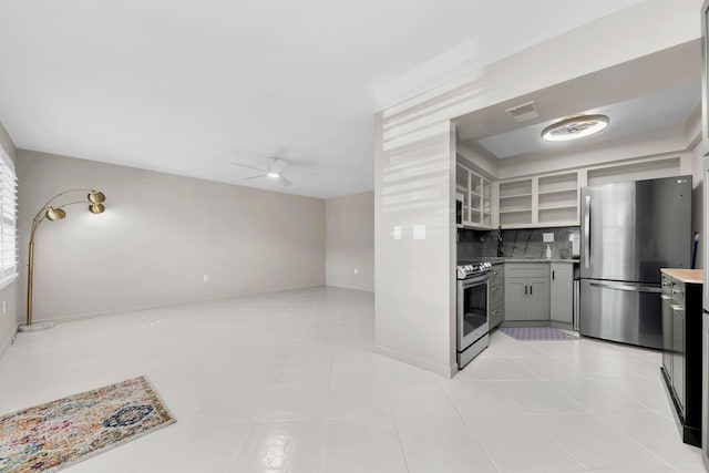 kitchen featuring gray cabinetry, backsplash, ceiling fan, appliances with stainless steel finishes, and light tile patterned flooring