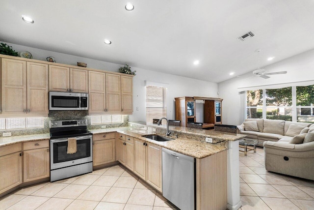 kitchen featuring kitchen peninsula, appliances with stainless steel finishes, vaulted ceiling, ceiling fan, and sink