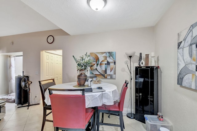 dining space with a textured ceiling and light tile patterned flooring