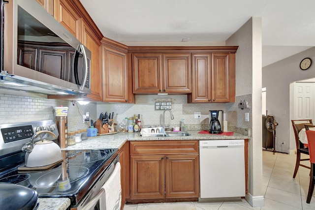 kitchen featuring light stone countertops, appliances with stainless steel finishes, tasteful backsplash, and sink