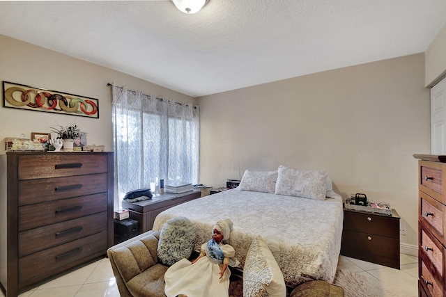 bedroom featuring light tile patterned flooring and a textured ceiling