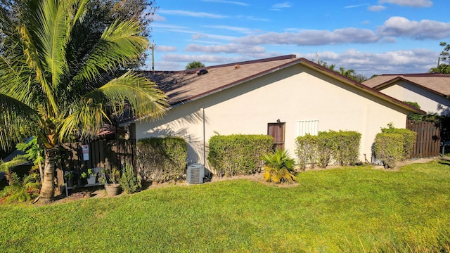 view of side of property with a yard and central air condition unit