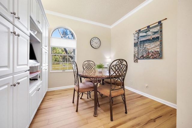 dining area featuring light wood-type flooring, crown molding, a textured ceiling, and baseboards