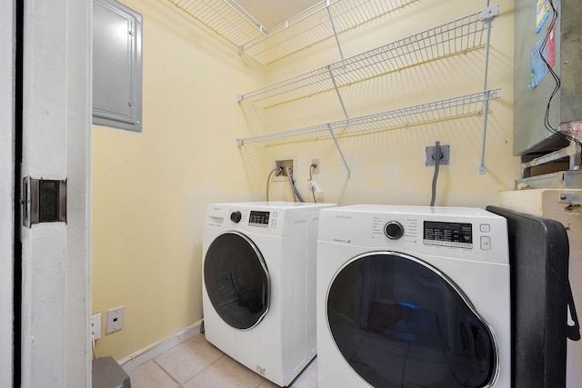 clothes washing area featuring light tile patterned floors, laundry area, baseboards, and washer and dryer