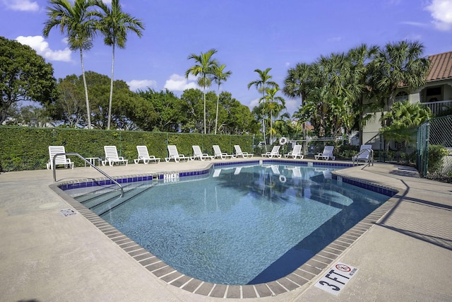 community pool featuring a patio area and fence