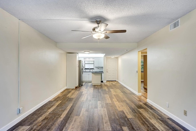 hallway with a textured ceiling and dark hardwood / wood-style floors