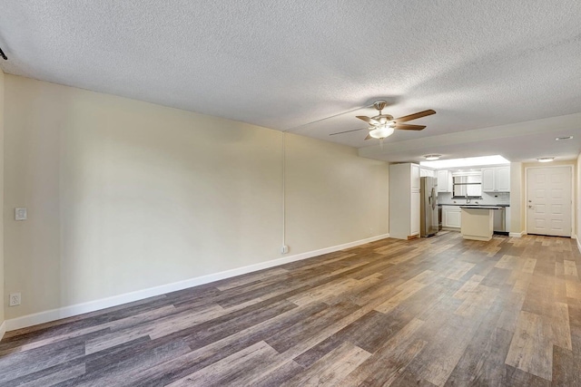 unfurnished living room with hardwood / wood-style floors, ceiling fan, and a textured ceiling