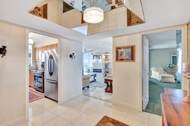 corridor with light tile patterned flooring and a chandelier