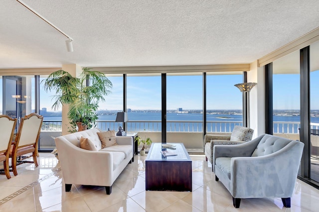 living room with light tile patterned floors, a textured ceiling, and a water view