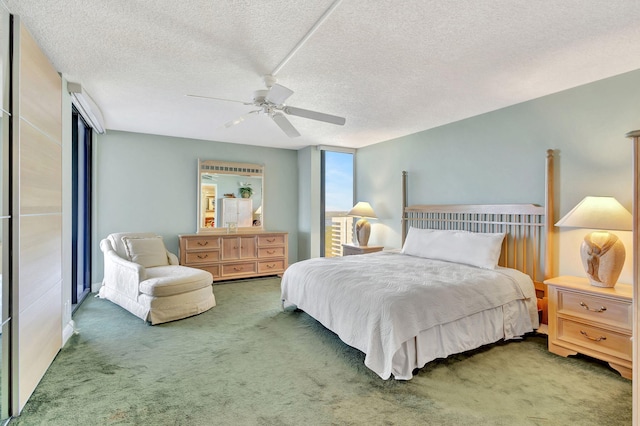 bedroom with ceiling fan, dark carpet, and a textured ceiling