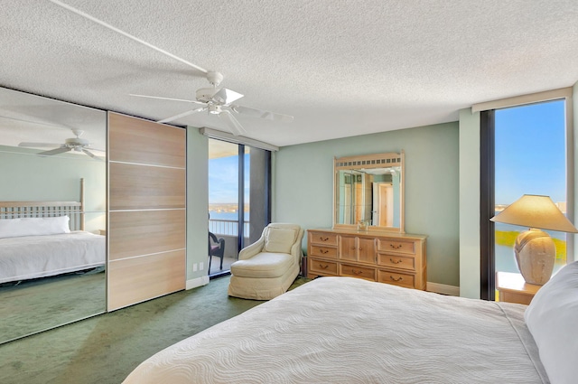 carpeted bedroom featuring access to outside, ceiling fan, and a textured ceiling