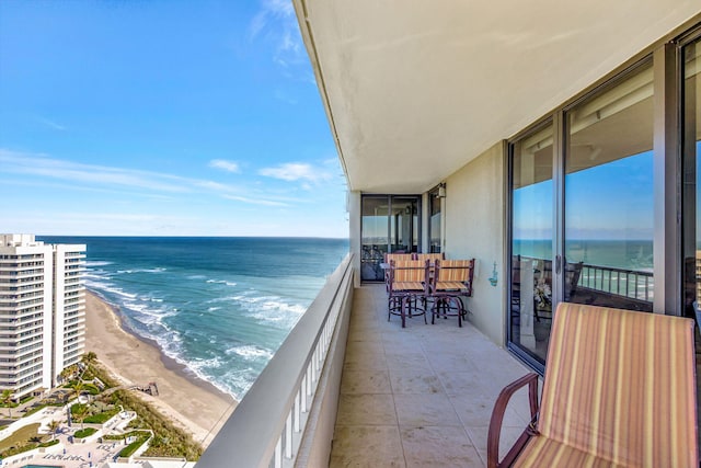 balcony with a water view and a view of the beach