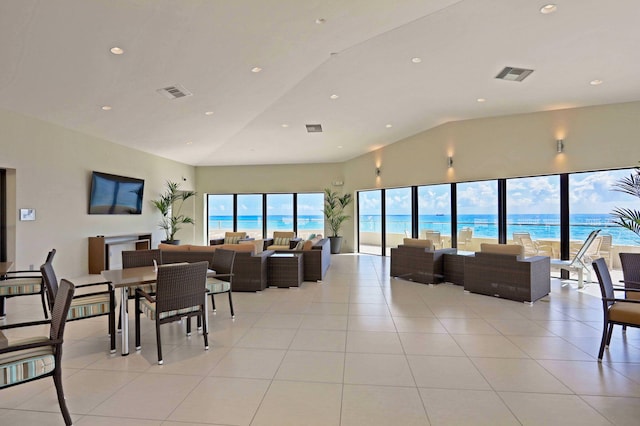 living room with a water view, light tile patterned flooring, and vaulted ceiling