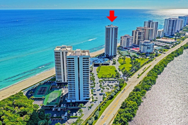 drone / aerial view featuring a water view and a beach view