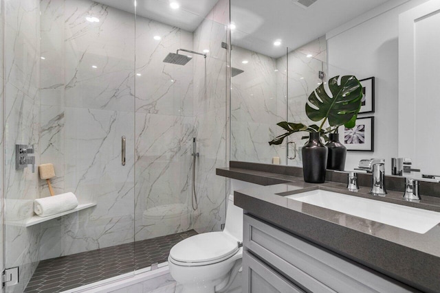 bathroom with walk in shower, vanity, and toilet