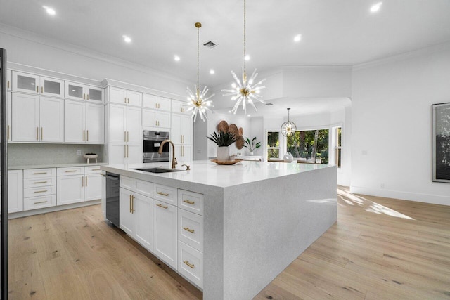 kitchen with pendant lighting, stainless steel appliances, a large island, and white cabinets