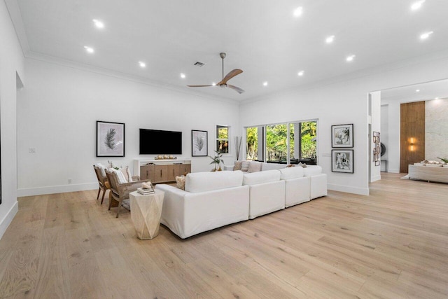 living room featuring ornamental molding, light hardwood / wood-style floors, and ceiling fan